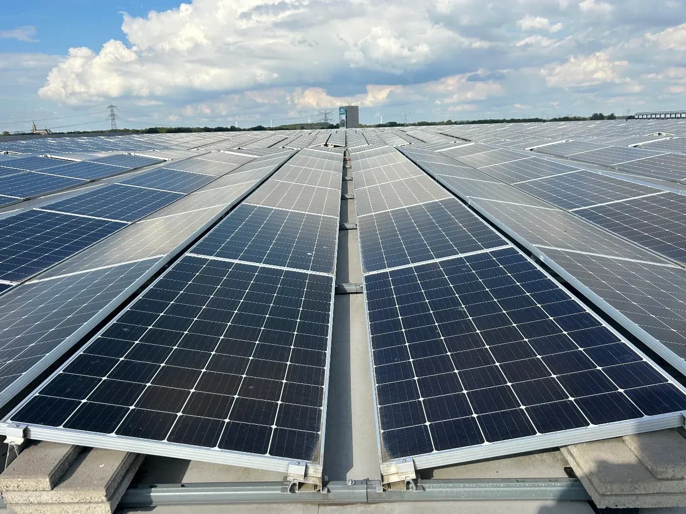 Grote dakinstallatie met zonnepanelen onder een blauwe lucht