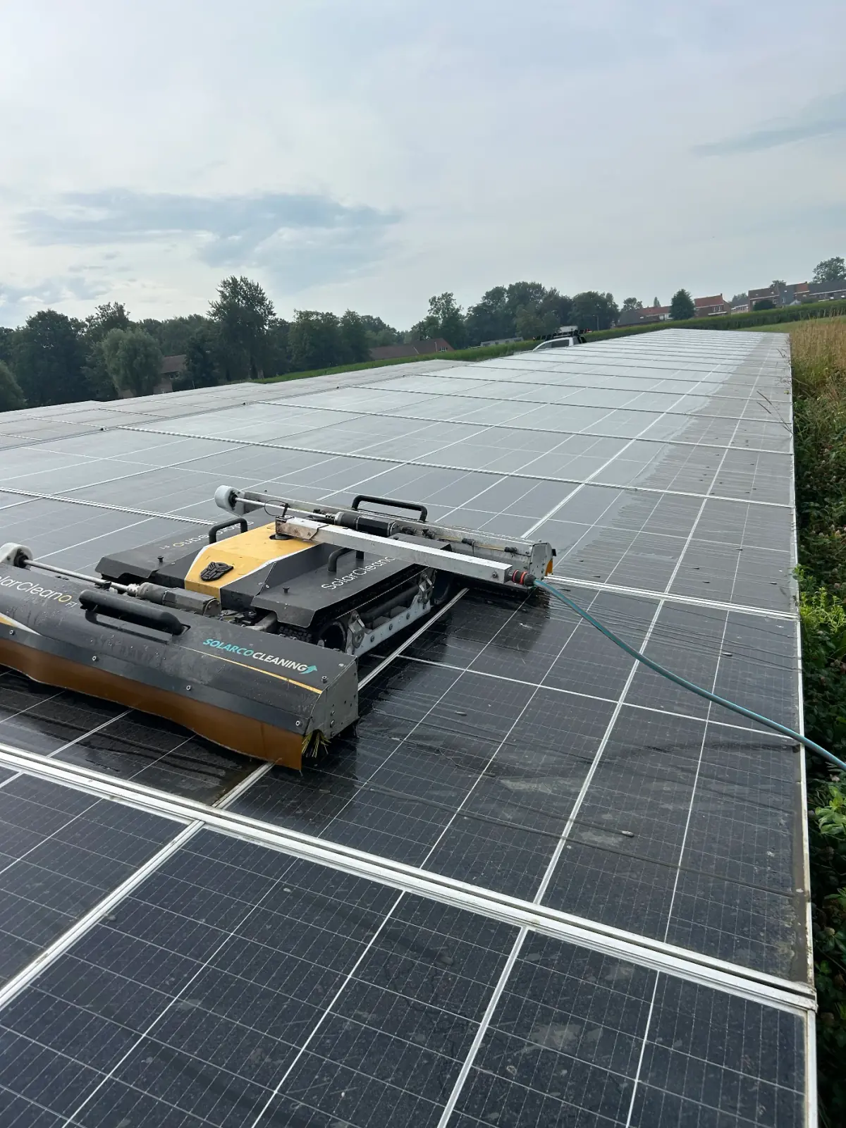 Gros plan d’un robot de nettoyage Solarco sur un toit équipé de panneaux solaires