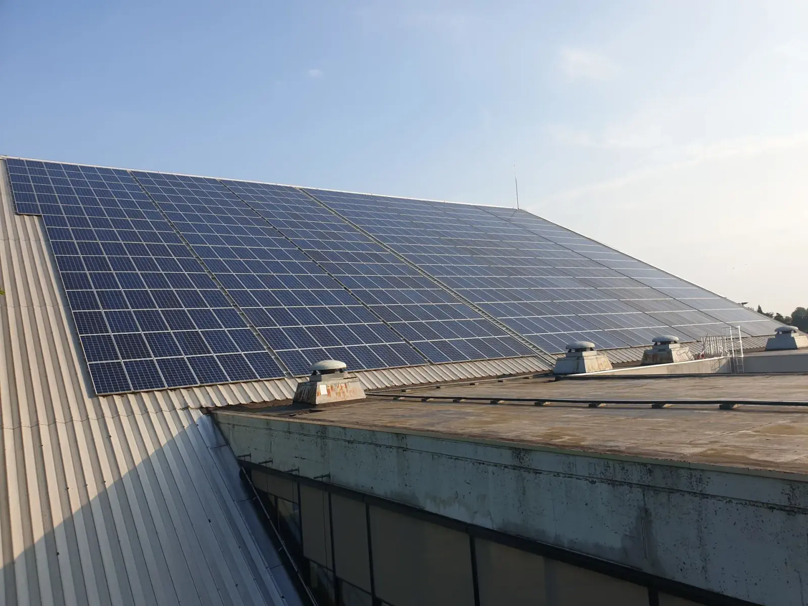 Grande toiture en pente d’un bâtiment d’entreprise, entièrement couverte de panneaux solaires