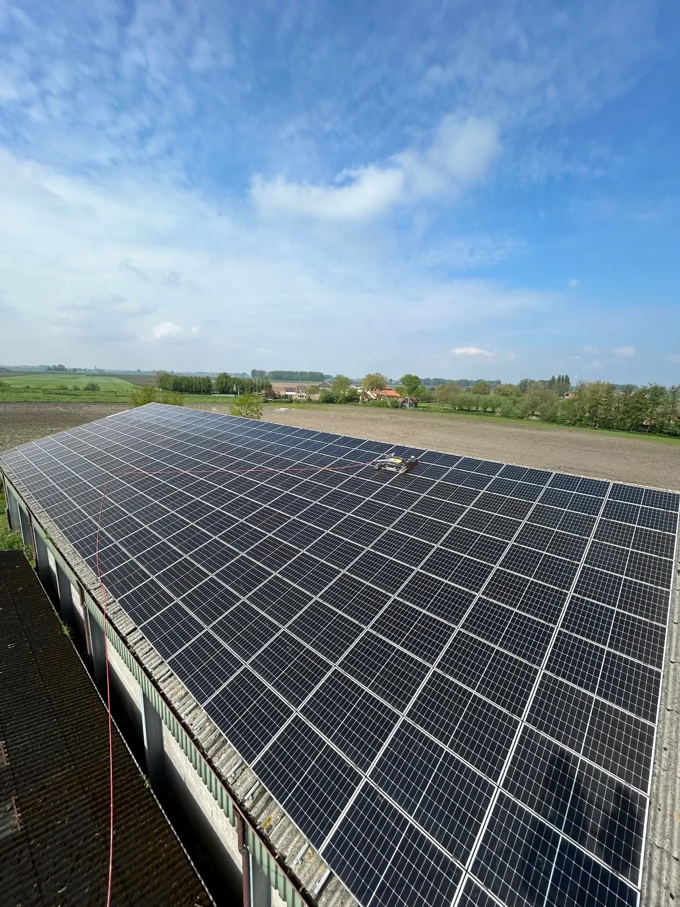 Grote dakinstallatie met zonnepanelen in een landelijke omgeving in West-Vlaanderen