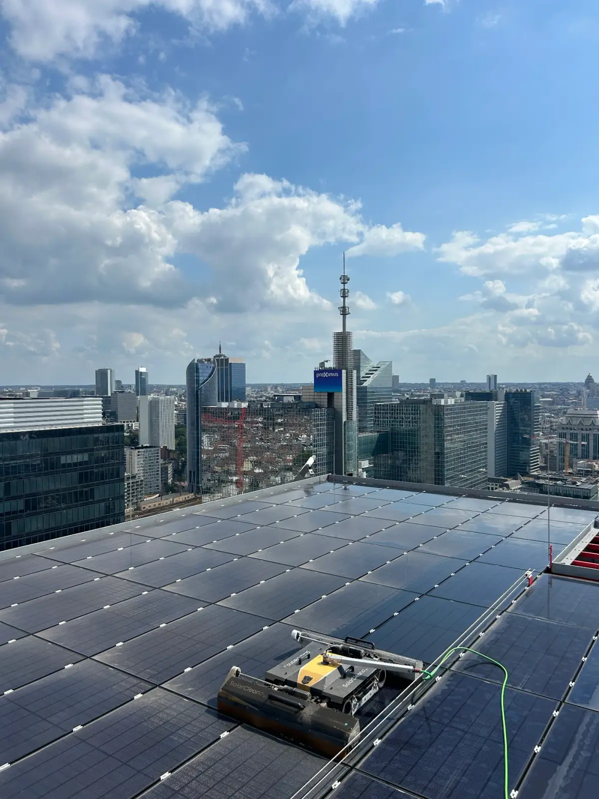 Panneaux solaires sur une toiture d’entreprise, avec le panorama de Bruxelles en arrière-plan