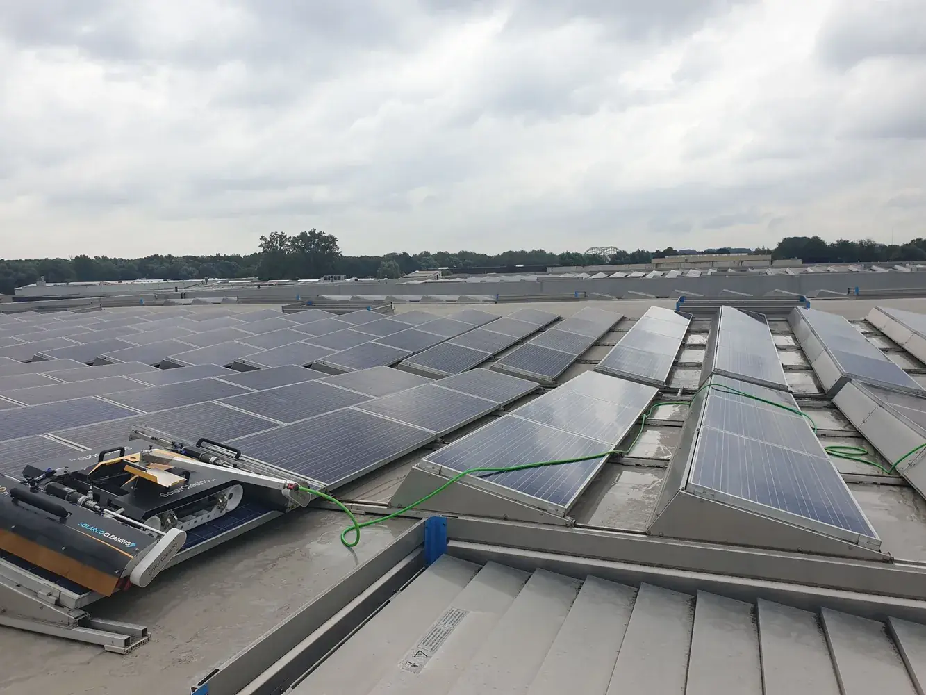 Robot de nettoyage Solarco sur un toit commercial équipé de panneaux solaires