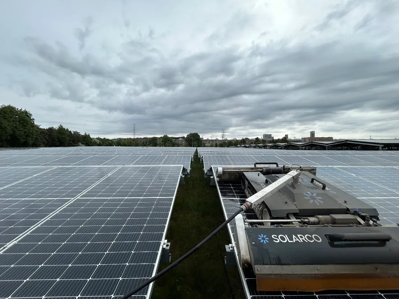 Reinigungsroboter von Solarco zwischen den Modulen eines großen Solarparks