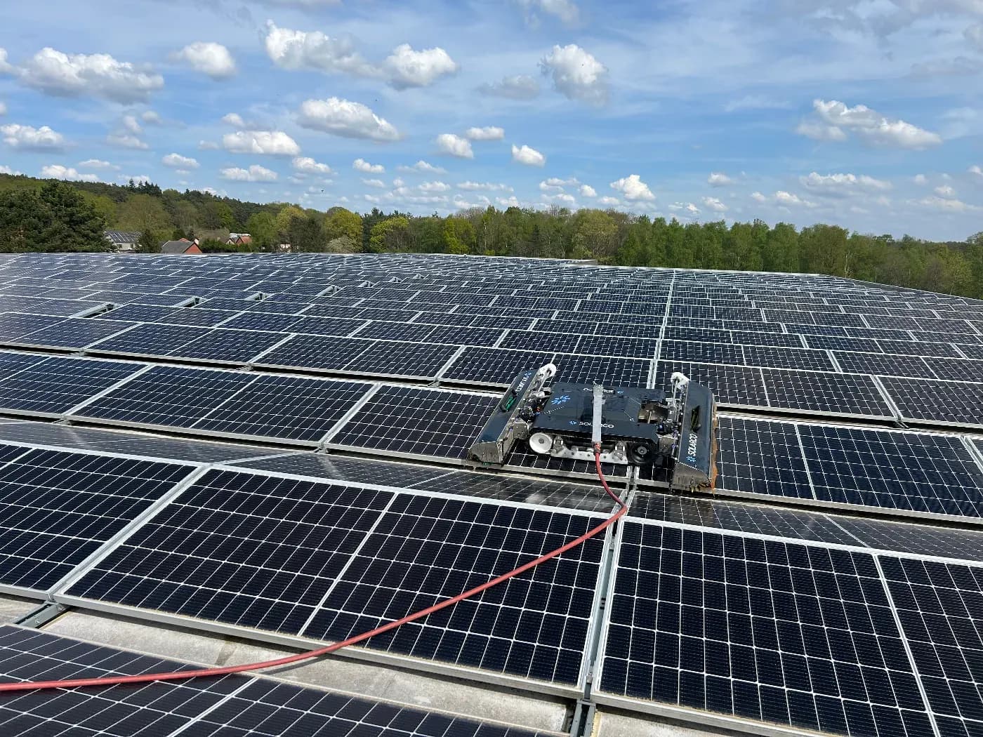 Reinigingsrobot aan het werk op een grote installatie met zonnepanelen