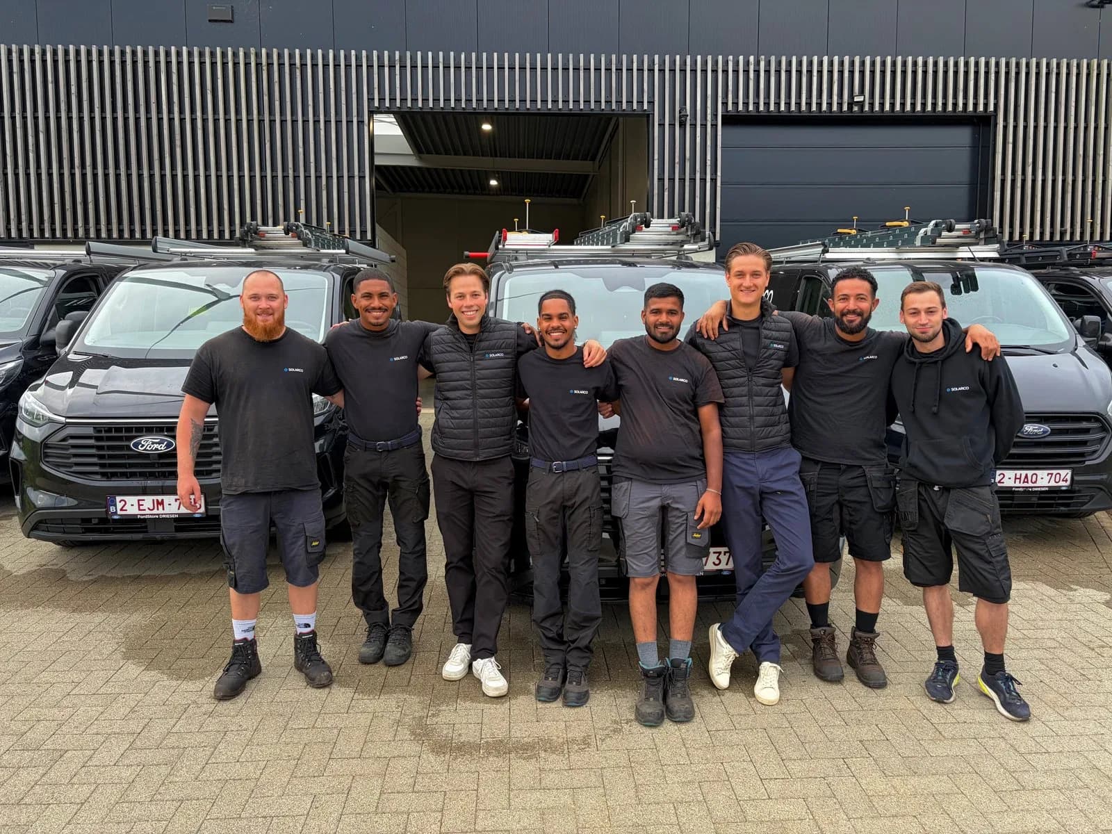 Das Solarco-Team vor dem Firmengebäude mit den Servicefahrzeugen